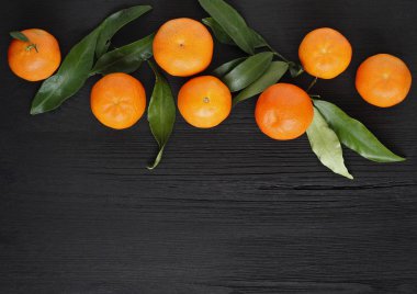 Siyah ahşap arka plan üzerinde bir sepet içinde Mandalina. Meyve sağlıklı gıda