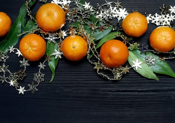 Tangerines in a basket on a black wooden background. Fruit healthy food