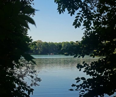 Yaz aylarında yaprakları tarafından çerçeveli banyo insanlarla Bavyera göl güzel görünümü