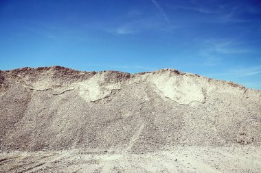 Mavi gökyüzüne karşı inşaat endüstrisi için çakıl tepeleri