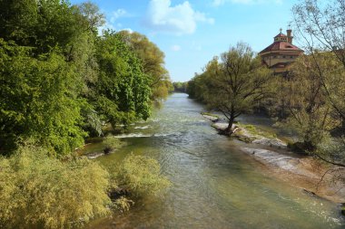 Panoramic spring view of Isar river in Munich with the baroque dome of the Muellersches  bath clipart
