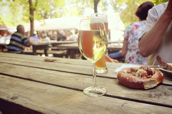 Food pause and relax at Bavarian beer garden, with pretzel,  a wine glass or a beer