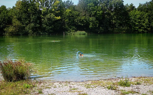 Garching, Bavaria - Summer hot weather in Bavaria, people take a swim at Garchinger See, small lake near Munich.