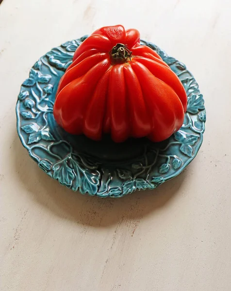 蓝色盘子里的巨大的牛肉心西红柿 — 图库照片