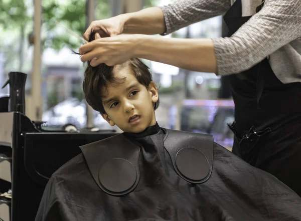 Cabeleireiros mãos fazendo penteado para criança menino na barbearia corte de cabelo profissional - Menino na barbearia corte de cabelo criança criança profissional recebendo seu primeiro corte de cabelo curioso — Fotografia de Stock
