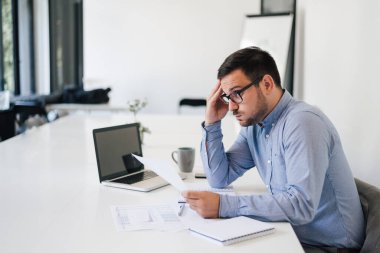 Stresli ve endişeli iş adamının portresi aşırı çalışan iş adamı görünümlü belgeler modern parlak ofiste baskı altında çalıştığını ve son teslim tarihinin boş bilgisayar ekranı olduğunu bildiriyor