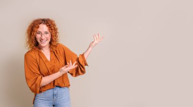 Genç satış elemanının portresi gülümsüyor ve beyaz arka planda fotokopi alanında yeni ürünler sunuyor