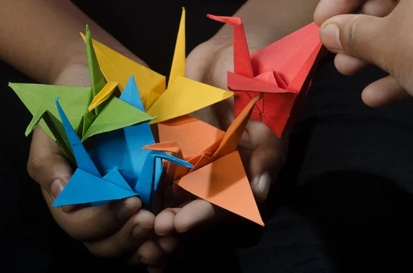 Young Girl with Origami Paper Crane (birds) in hand makes a wish. Inspired by the Japanese legend that one who creates a thousand origami cranes will be granted a wish.