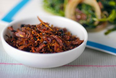 Kapatın. İştah açıcı Baharatlı Maldivler balık tabağı - (kurutulmuş balık) yapraklı yeşil su ıspanağı kızartması ile. Asya mutfağı. 