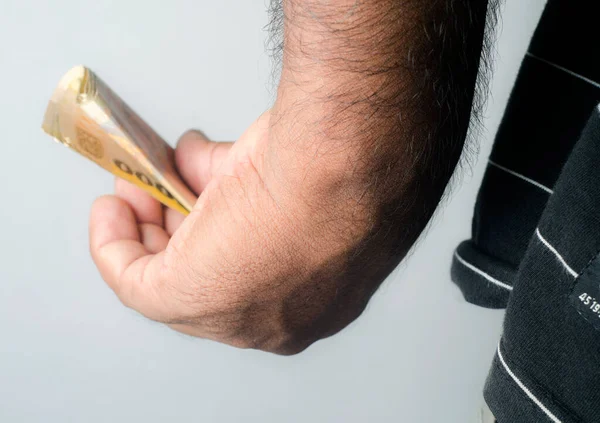 Adam parayı elinde tutuyor. Rüşvet, kara para, intikam, kâr. Kapat. Beyaz izole arkaplanda hareket var