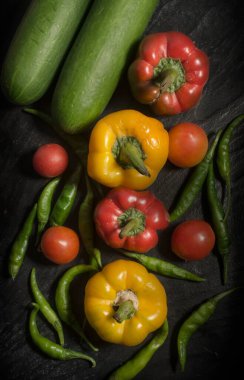 Domates, Capsicum, Yeşil Chili, ve Gherkin Salatalık Sebzesi Granit zeminde. Üst açı.