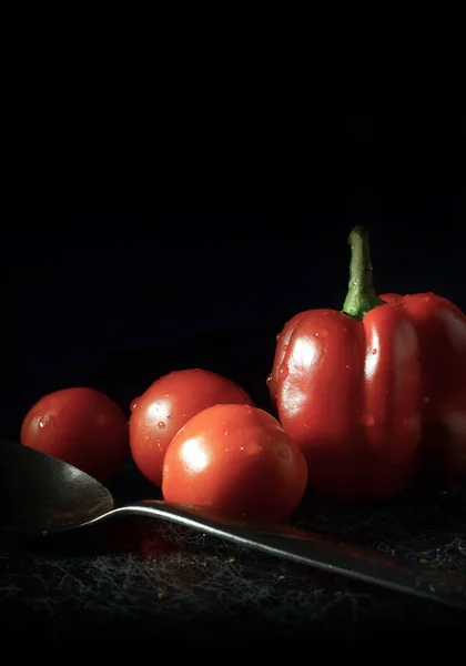 Kara kaplı arka planda taze domates ve kırmızı çan biberi..