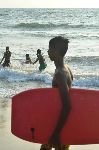 Lavinia Dağı Sahili. Colombo, Sri Lanka. 05 Mart 2016. Sahilde gündoğumu geçmişine sahip genç bir sörfçünün silueti.