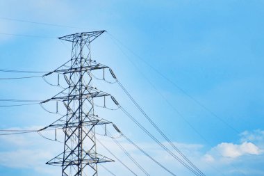 Yüksek gerilim pole ve tel ile mavi gökyüzü ve bulutlar.