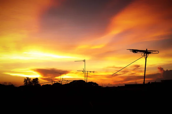Silhouette of Beautiful sunset with television antenna or telecommunications towers have a lot of different antennas, Orange sky with clouds. Nature background.