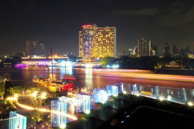 Gece saatlerinde Chao Phraya Nehri'nde gemi veya tekne yelken uzun pozlama, Bangkok, Tayland. Su taşımacılığından aydınlatma. Işık izleri güzel.
