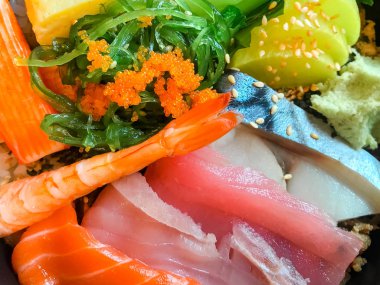 Japon yemekleri sashimi. Karışık dilimlenmiş çiğ balık seti. Somon balığı, Ton balığı, Saba balığı, Somon karacası, Yengeç çubukları, Tamago suşi, Chuka wakame, Beyaz susam, Haşlanmış sebzeler ve Vasabi.