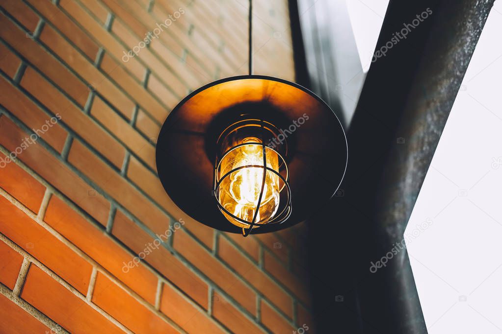 Vintage LED edison lamp or Incandescent light bulb in Restaurant or Cafe with Ancient block wall with brown and orange tone.