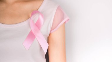 Kadının sol göğsünde beyaz arka planda beyaz tişört giyen pembe kurdele göğüs kanseri sembolü, göğüs kanseri farkındalığı ayı. Ekim 'de önemli günler
