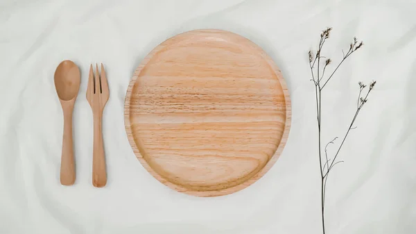 板木製 スプーン木製 白い布にリムニウム乾燥花で木製をフォークします 台所用品のモックアップ 白背景のテーブル設定のトップ表示 — ストック写真