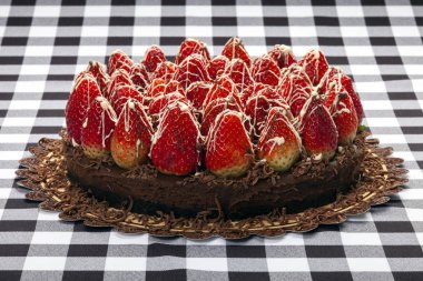 Taze çilekle süslenmiş çikolatalı pasta.