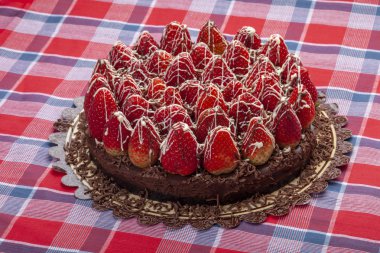 Taze çilekle süslenmiş çikolatalı pasta.