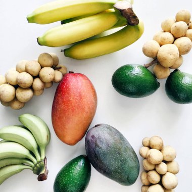 Beyaz bir arka plan üzerinde düz yatıyordu karışık tropikal meyve. avokado, muz, yeşil altın muz, longkong, guava ve kırmızı mango Tayland, üstten görünüm