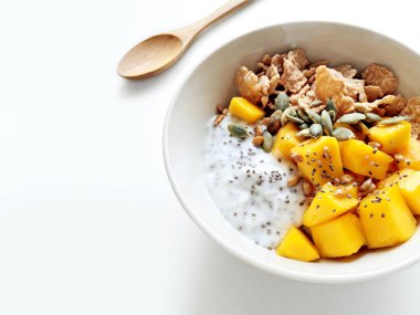Chia tohum puding, mango, tahıl, kabak çekirdeği ve ayçiçeği tohumu kopya alanı bir mutfak masada ile sağlıklı kahvaltı kase