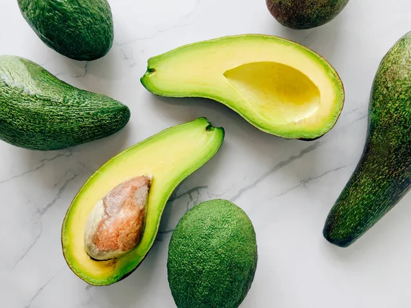 Gehalveerde Avocado Een Marmeren Achtergrond Bovenaanzicht — Stockfoto