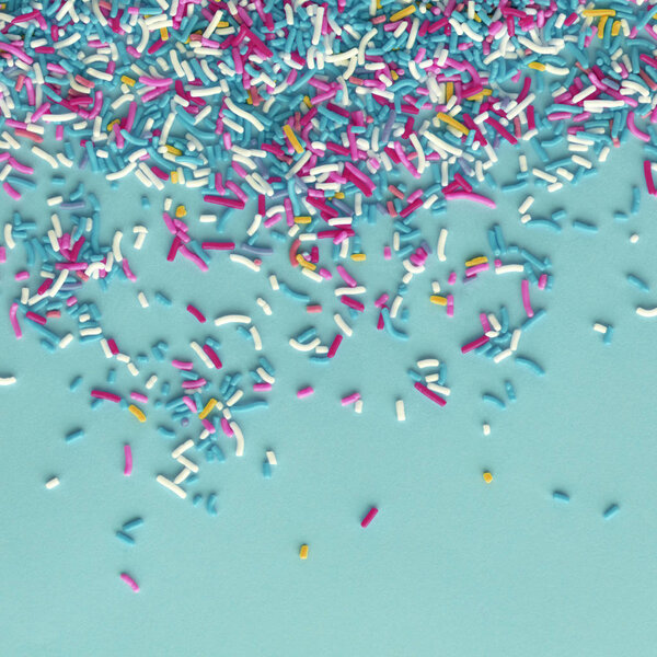 Colorful sprinkles on a blue background, top view with copy space