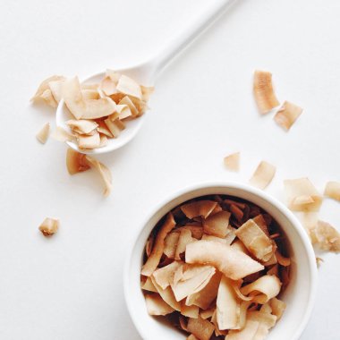 Üstten görünüm, beyaz bir arka plan kavrulmuş Hindistan cevizi cips