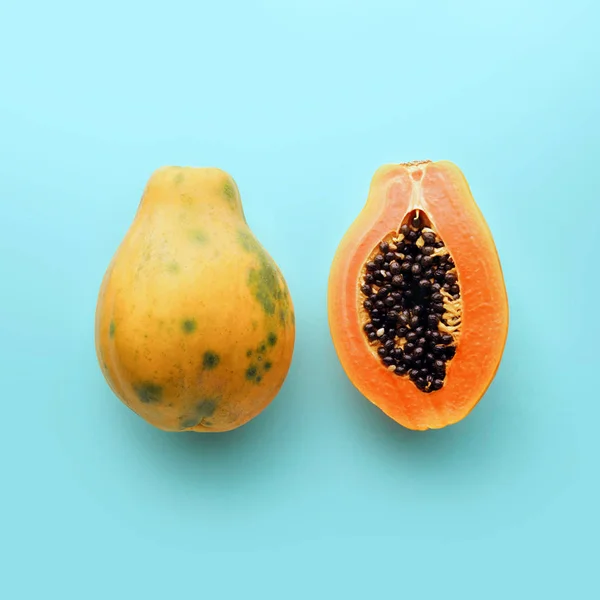 Pastel mavi arka plan, yaratıcı yiyecekler kavramı, üzerinde Hawaii papaya tropikal meyve düz yatıyordu