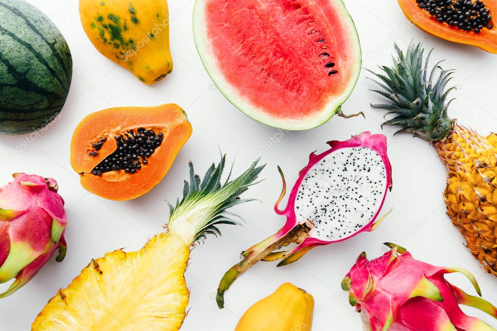 Flat lay tropical fruit layout made of dragon fruit, watermelon, papaya and pineapple. Creative summer food concept.
