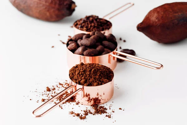 Rose Gold Measuring Cups Cocoa Beans Cacao Nips Cocoa Powder — Stock Photo, Image