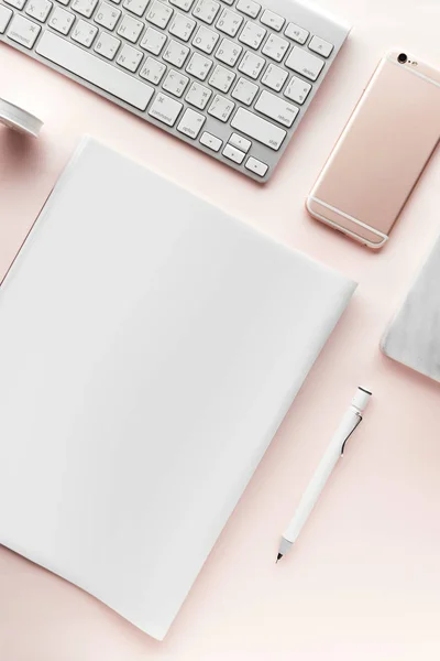 Yaratıcı düz çalışma alanı en az tarzı ile yatıyordu. Bilgisayar, smartphone, dergi, defter, kalem ve tapeline pastel pembe arka plan, üstten görünüm üzerinde modern resepsiyon