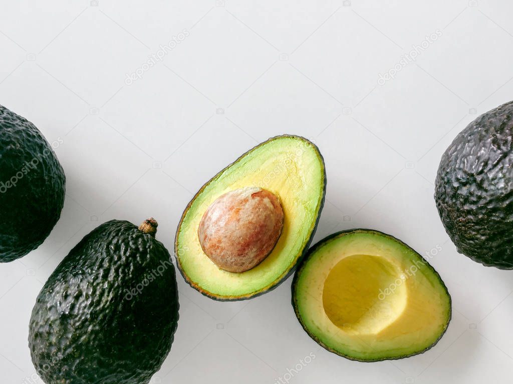 Fresh organic hass avocados on a white background, top view with copy space