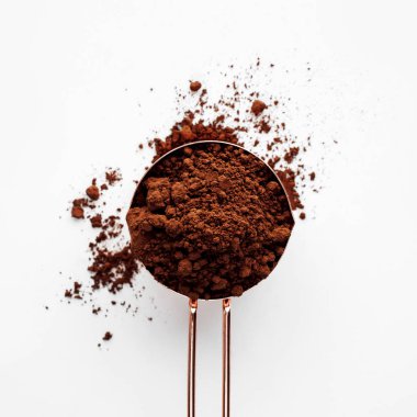 Altın ölçüm fincan kakao tozu sağlıklı gıda kavramı, beyaz bir arka plan gül