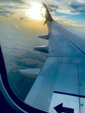 Uçak penceresinden ve günbatımı gökyüzü kabarık bulutlar üzerinde uçan ve seyahat eden konsept arkaplanından görünüm