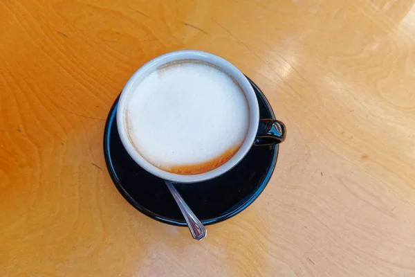 木製の背景に熱いカプチーノ コーヒー黒カップ — ストック写真