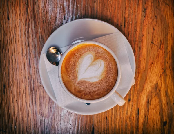 Kopi Cappuccino Panas Dengan Buih Berbentuk Hati Atas Meja Kayu — Stok Foto