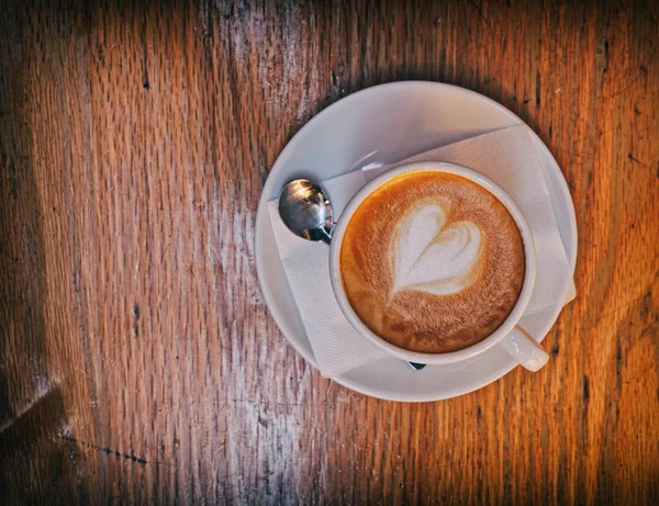 Kopi Cappuccino Panas Dengan Buih Berbentuk Hati Atas Meja Kayu — Stok Foto