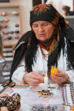 Vinnitsa, Ukrayna - 19.03.2018: yaşlı kadın pysankar Paskalya yortusu yumurta pysanka etnografik ana sınıfı üzerinde bir çiçek halk süs yazıyor