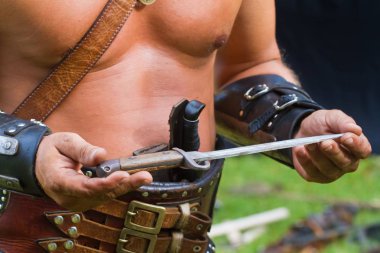 Yakushyntsi, Ukrayna-22.06.2019: Zaporozhian sich kazak, kozak kharakternyk, üstsüz bir deri kemer giyen, kendi kendine yapılmış bir bıçak, yaşayan yangın Midsummer pagan Ethno Festivali 'nde Ukraynalı ataların ortak silah tutan