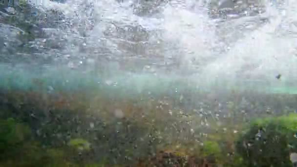 Briser les éclaboussures de vagues et faire des bulles d'air dans la zone supralittorale de la mer Noire, des images de plongée sous-marine, des pierres couvertes d'algues vertes et de petits poissons juvéniles nager dans l'eau salée — Video