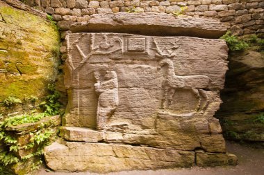 Busha, Ukrayna - 09.06.2019: Taşa oyulmuş ağaç, kadın ve geyik figürleri, yaşam sembolleri, annelik ve klan sembolleri, dini turistik turistik şehir simgeleriyle antik pagan mağara tapınağının detayları