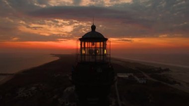 Sahile güneş doğarken bir dron 4 k tarafından görüldüğü gibi bir deniz feneri ile