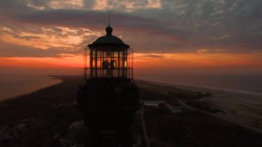 Sahile güneş doğarken bir dron 4 k tarafından görüldüğü gibi bir deniz feneri ile