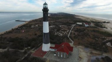 Bir deniz feneri ve kıyı hava görünümünü güneşli bir kış gününde yakından bir dron tarafından görüldüğü gibi