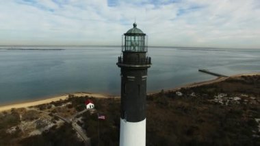 Bir deniz feneri ve kıyı hava görünümünü güneşli bir kış gününde yakından bir dron tarafından görüldüğü gibi