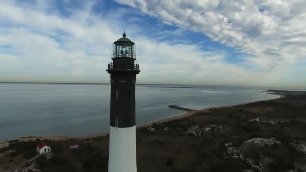 ドローンから見た灯台の海岸線空撮が晴れた冬の日にクローズ アップ — ストック動画